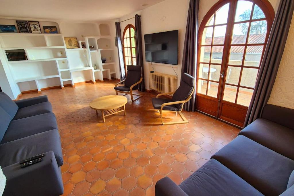 een woonkamer met een bank, stoelen en een tafel bij T4 Furesta - Casa Mattea in Aléria