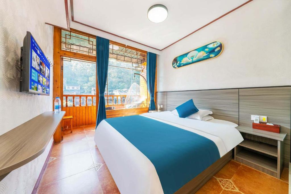 Postel nebo postele na pokoji v ubytování Fenghuang Memory Linjiang Inn
