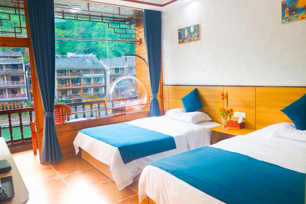 Postel nebo postele na pokoji v ubytování Fenghuang Memory Linjiang Inn