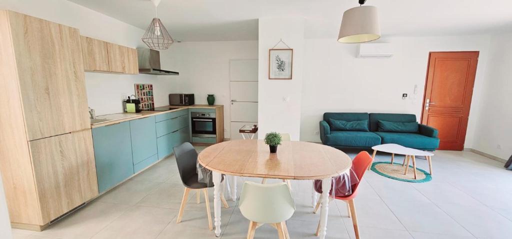 une cuisine et une salle à manger avec une table et des chaises dans l'établissement La Cigale du Lubéron, à Beaumont-de-Pertuis
