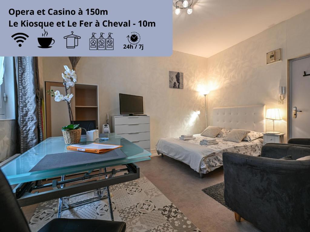 une chambre avec un lit et une table dans une pièce dans l'établissement Séjour à la source - Opéra, casino, kiosque, à Vichy