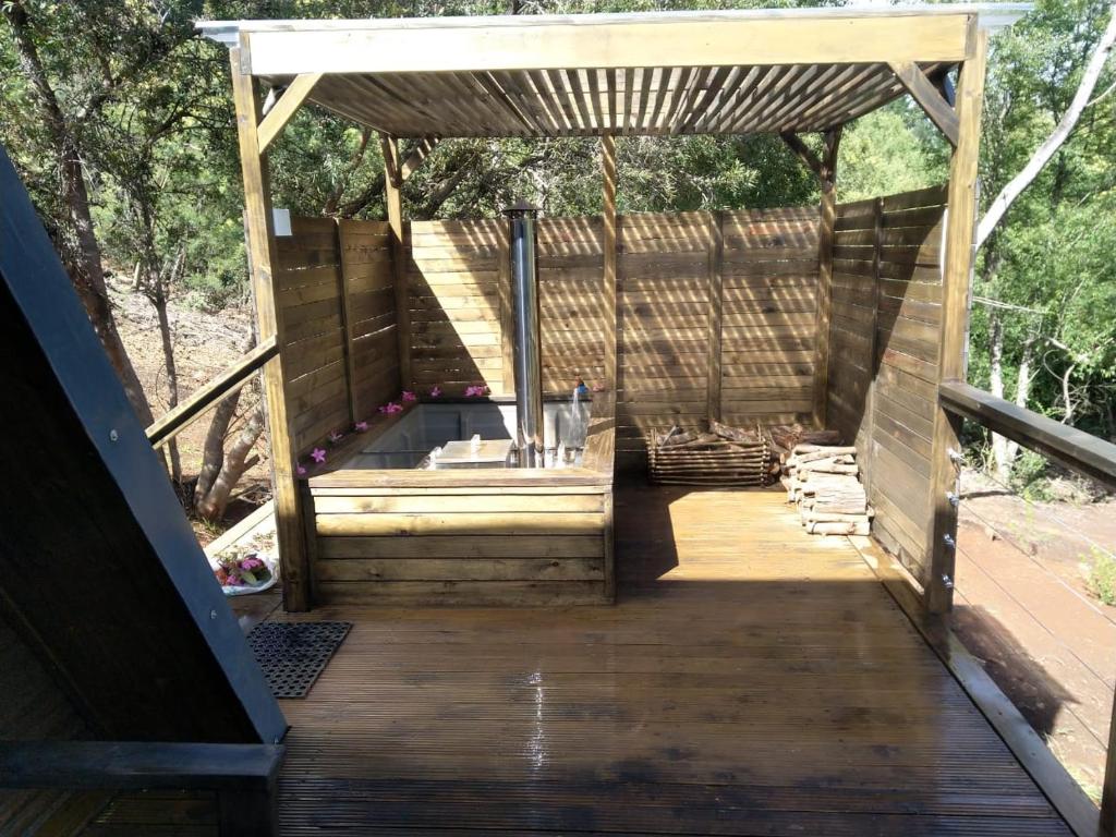 a wooden deck with a hot tub under a pergola at Treehaven Retreat in Hogsback