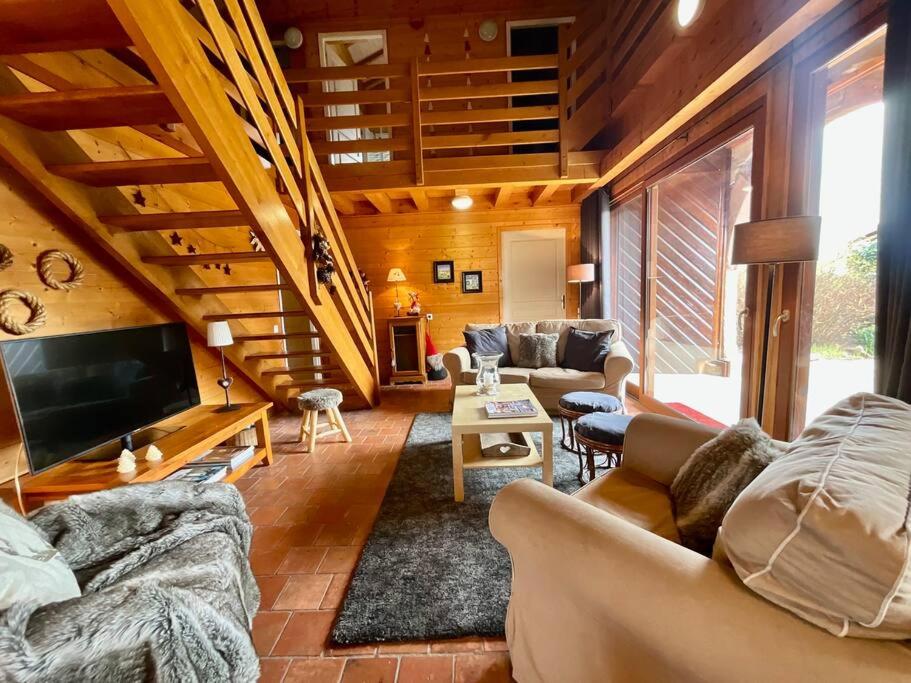 duży salon z kanapami i telewizorem w obiekcie La Charmelle - Belle maison avec jardin & terrasse w mieście Corcieux