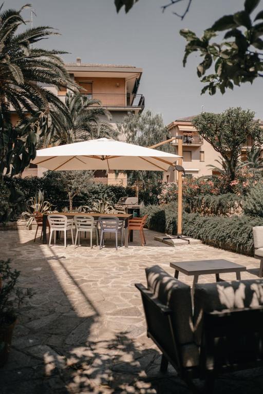 a patio with tables and chairs and an umbrella at Casa Pirouette in Alassio