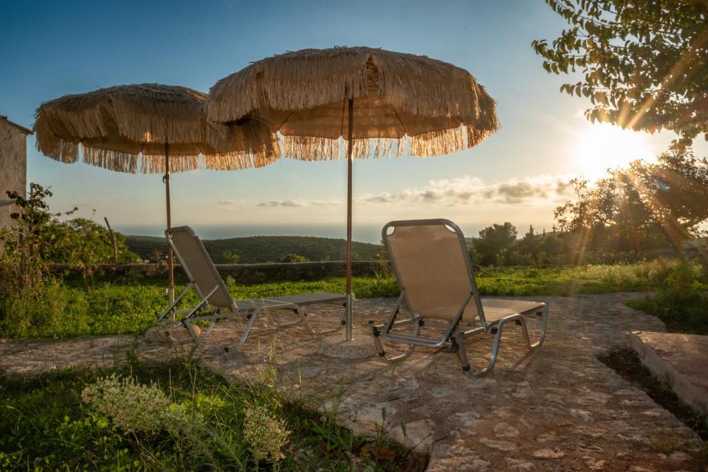 Duas cadeiras e dois guarda-sóis num pátio em Villa MarFo Natural Park by "elite" em Maryiés