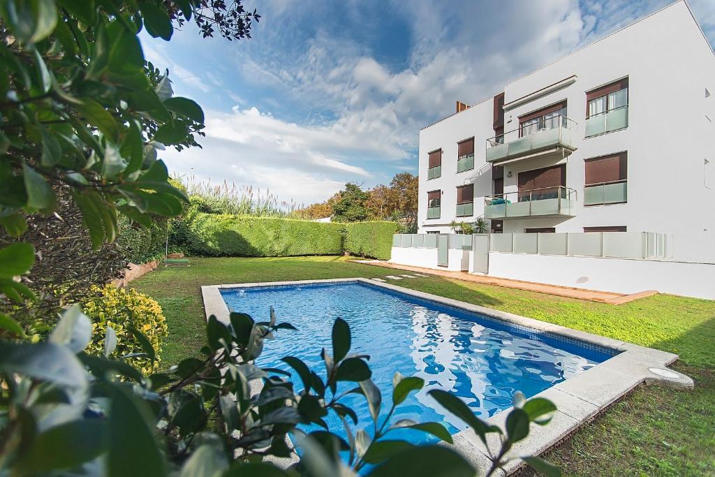 una piscina in un cortile accanto a un edificio di WELCS APARTAMENTO 189 PDA con piscina comunitaria a S'Agaró