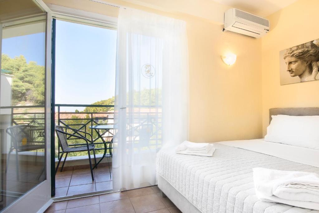 a bedroom with a bed and a balcony at Julia Hotel in Fourka