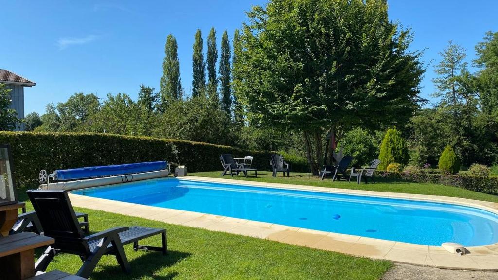 - une piscine dans une cour avec des chaises et des arbres dans l'établissement Gîte yourte Bulle Der au Lac du Der jusque 8 personnes, à Giffaumont