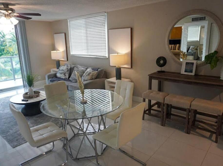 Una sala de estar con una mesa de cristal y un sofá. en Comforts of Home in Updated Condo by the Beach, en Boca Raton