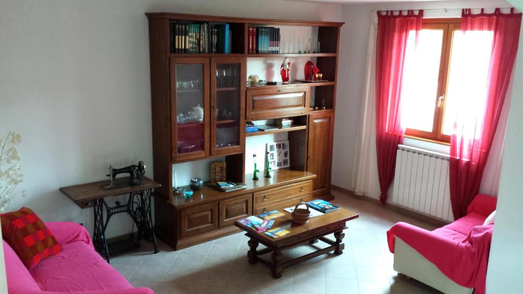 ein Wohnzimmer mit 2 Stühlen und einem Bücherregal in der Unterkunft Casa Roberta in Cavriglia