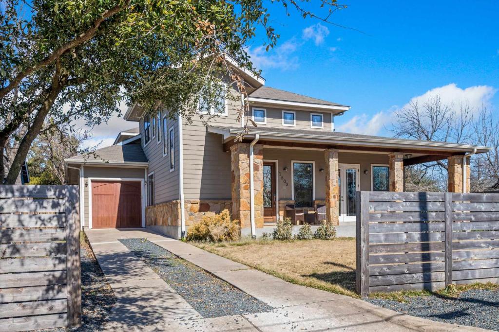 a house with a fence in front of it at Bright Home in East ATX - 3BR - Cowboy Pool in Austin