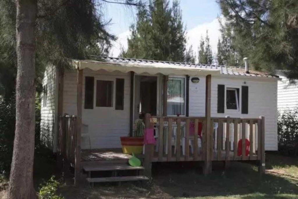 a small white tiny house with a porch at Camping 4 étoiles - Parc aquatique - eebaha in Hyères
