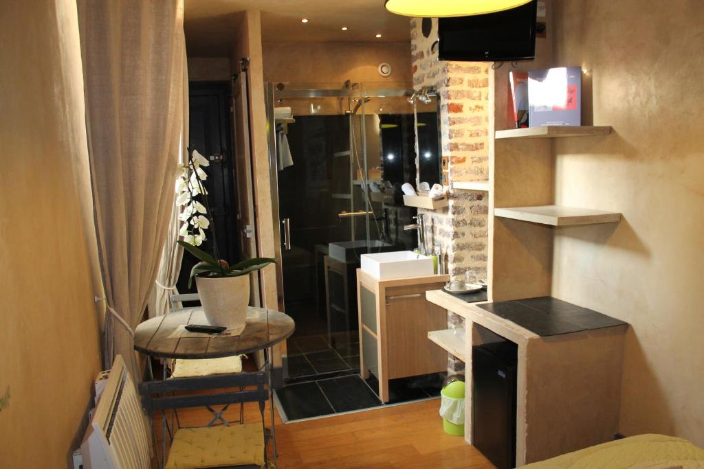 a bathroom with a sink and a shower in a room at Côté Chambres in Charleville-Mézières