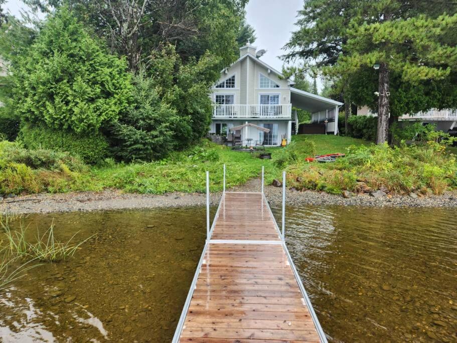 a dock in the water in front of a house at Petit Elgin, quai Bord de l'eau, foyer, SPA in Stratford