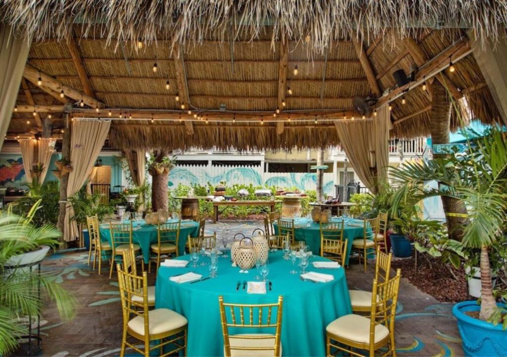基韦斯特Havana Cabana at Key West的一间设有蓝色桌椅的餐厅,种植了植物
