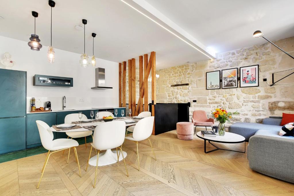 un salon et une salle à manger avec une table et des chaises dans l'établissement SERENERS - Charming Serviced Apartments - Place des Vosges, à Paris