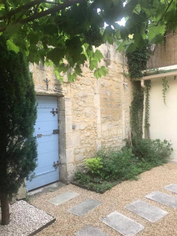 un garage bleu à côté d'un bâtiment en pierre dans l'établissement Maison de ville provençale Tarascon 13150, à Tarascon