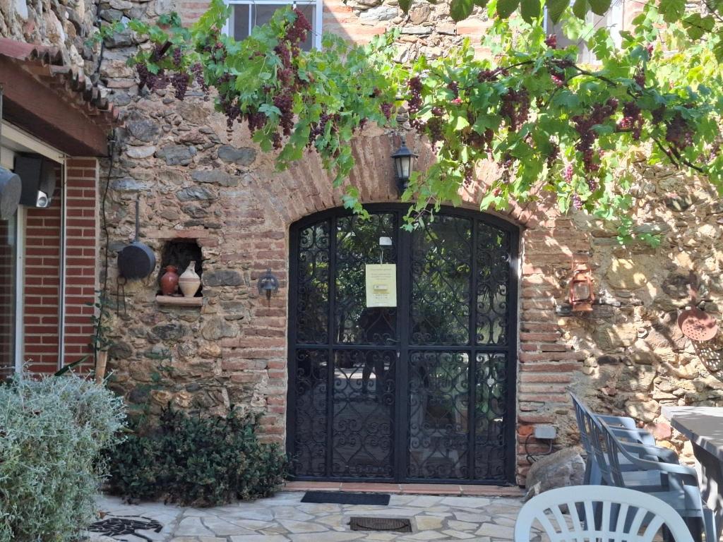 a black door in a brick building with a stone wall at Mas des Olivettes in Montauriol