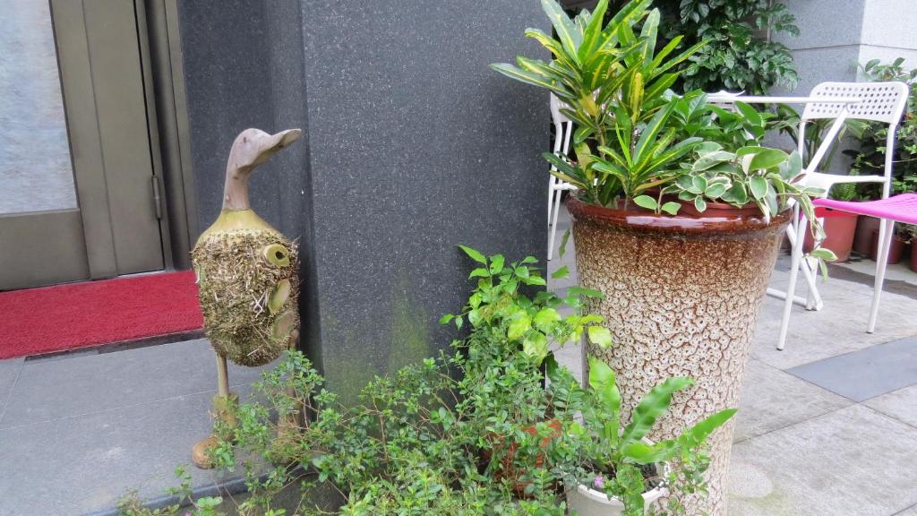 a bird statue standing next to two potted plants at Slower Life B&amp;B in Jiaoxi