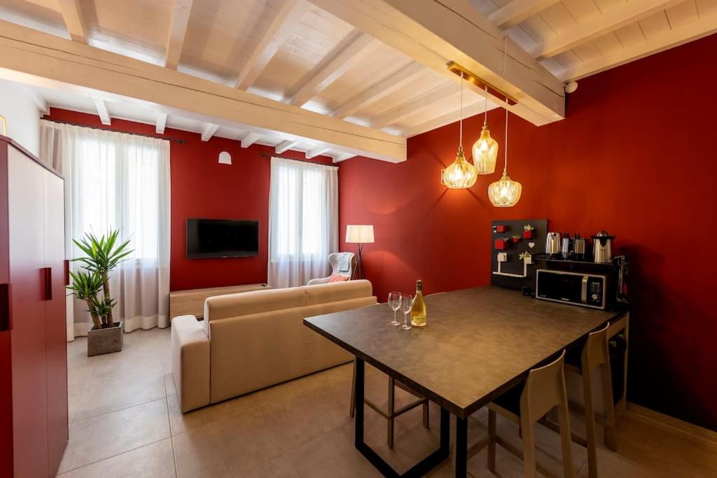 a living room with red walls and a table and a couch at Red Suite - City center & Garage in Parma