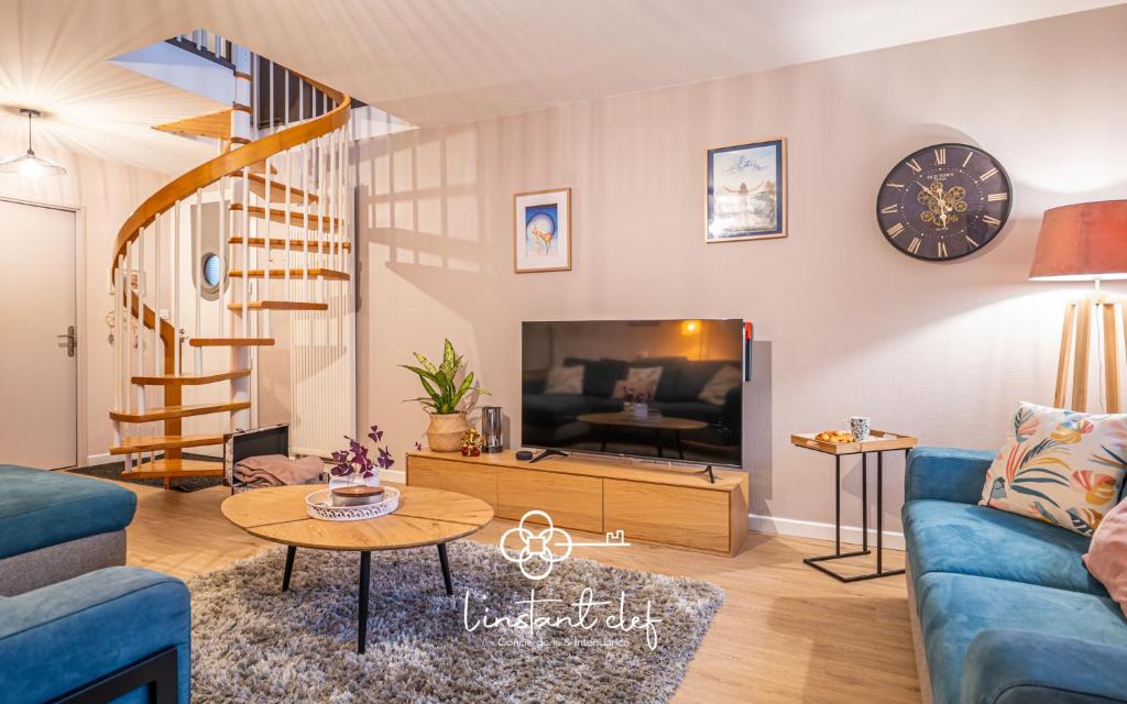 un salon avec un canapé bleu et une télévision dans l'établissement Maison familiale à Spay avec piscine, jeux & piano, à Spay