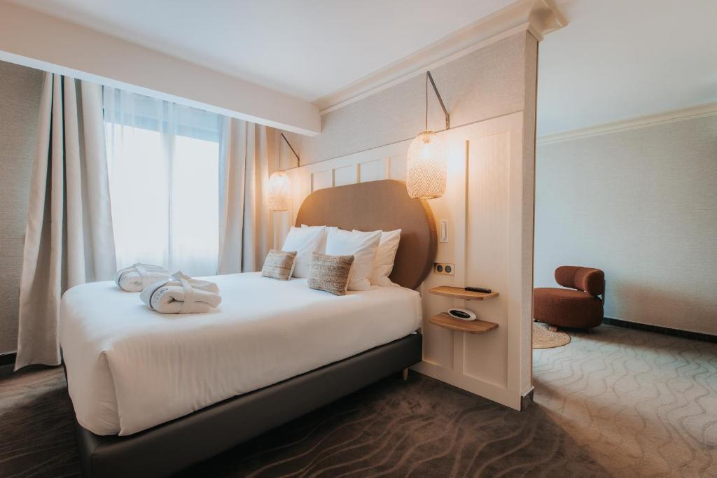 Postel nebo postele na pokoji v ubytování Hôtel Henry II Beaune Centre
