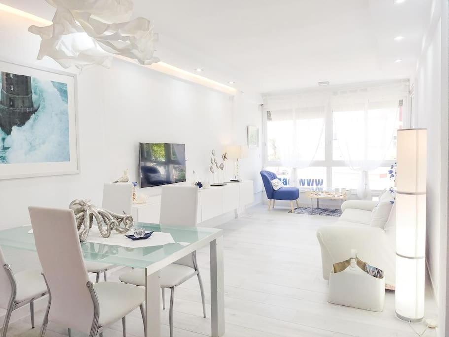 een witte woonkamer met een tafel en stoelen bij QBF Quality Beachfront in Torre del Mar