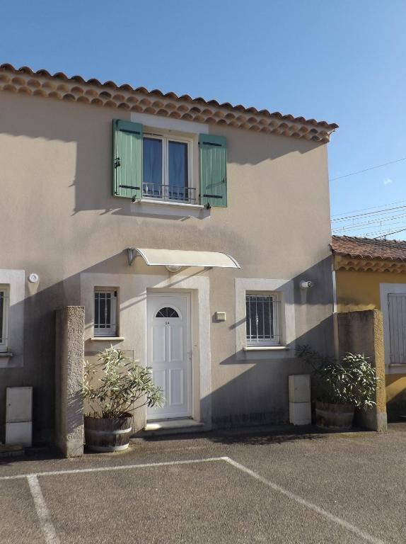 une maison avec une porte blanche et des fenêtres vertes dans l'établissement Maison La p'tite pause, à Piolenc