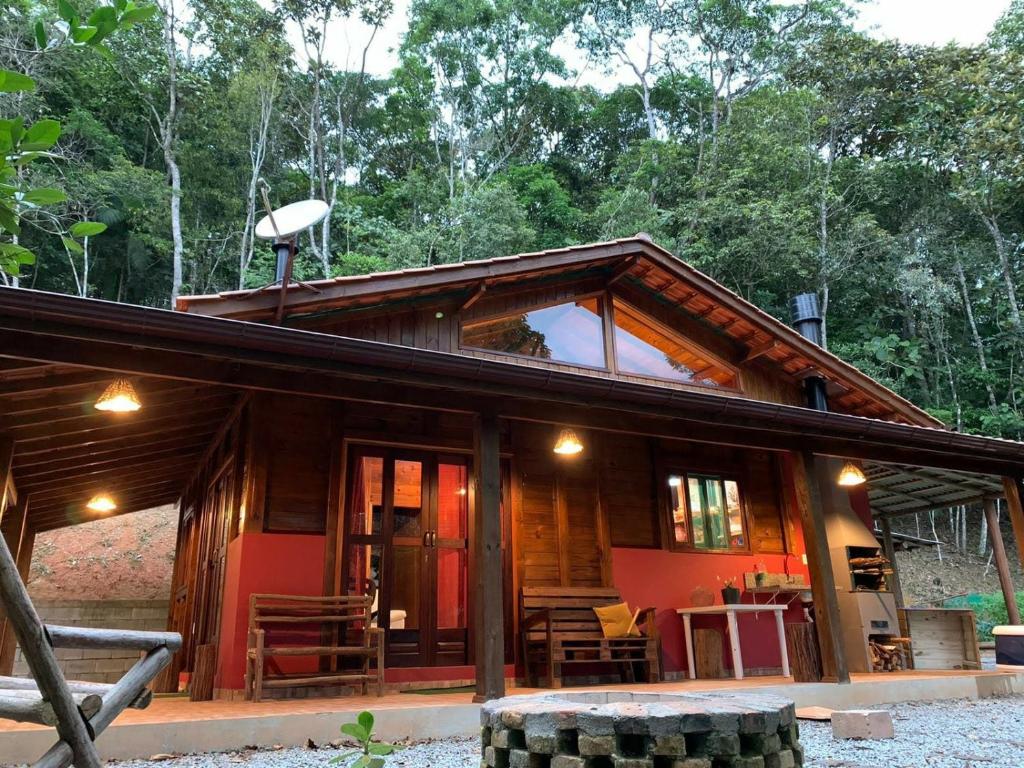 a cabin in the woods with a large window at Casa de Campo Rio Miguel in Aguas Mornas