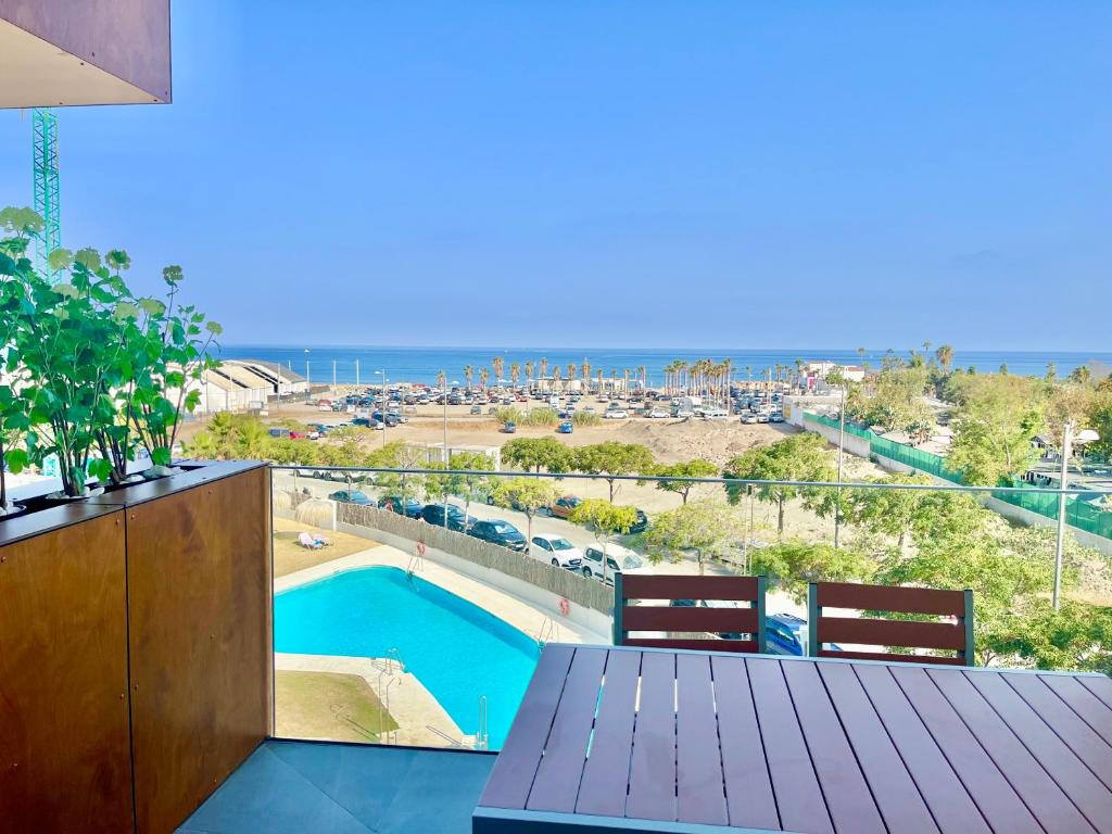 Un balcón con mesa y sillas y una piscina. en El Balconcito, en Torre del Mar