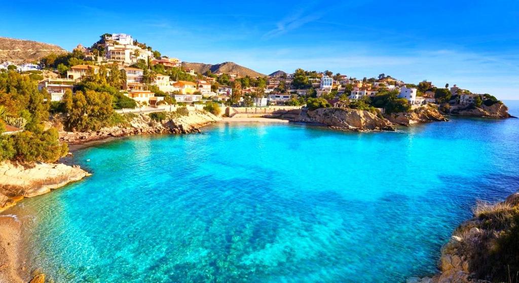 una vista di una spiaggia con case su una collina di Apartamentos La Mar a 40 metros de la playa a El Campello