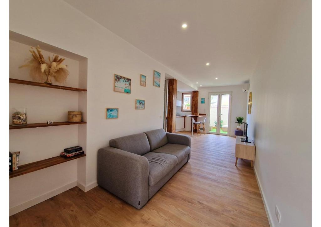 un salon avec un canapé et une table dans l'établissement Appartement de charme proche de la mer, à Palavas-les-Flots