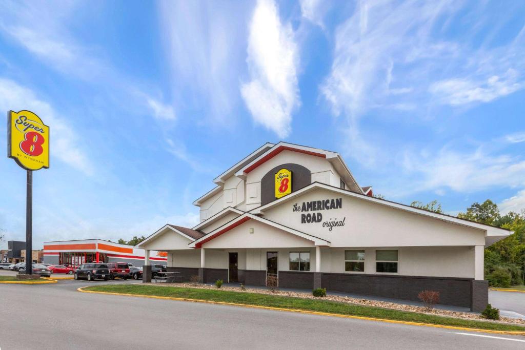 un edificio con un cartel de posada de sándwiches en un estacionamiento en Super 8 by Wyndham Summersville - New River National Park, en Summersville