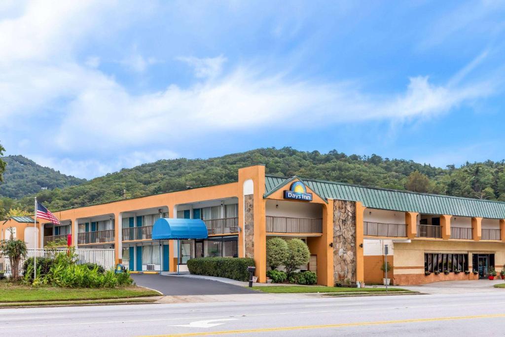 a front view of a hotel with a mountain in the background at Days Inn by Wyndham Clayton in Clayton