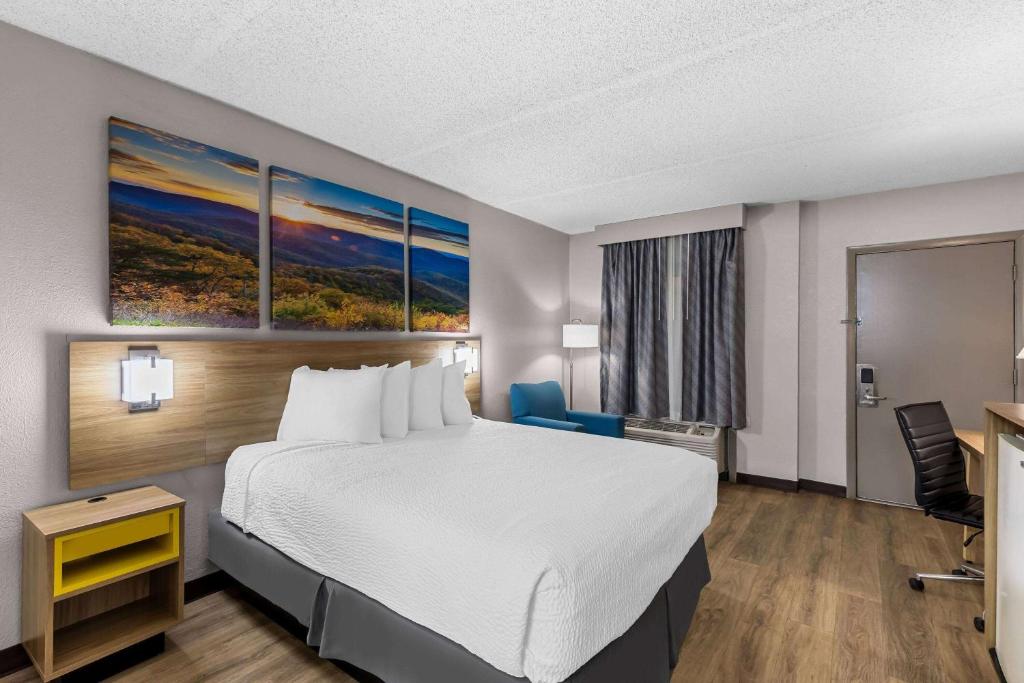 a hotel room with a bed and a desk at Days Inn by Wyndham Clayton in Clayton