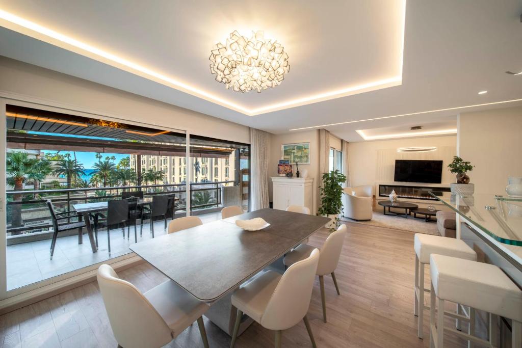 une salle à manger et un salon avec une table et des chaises dans l'établissement REF 1924 - Cannes Croisette - Sea view apartment for rent, à Cannes