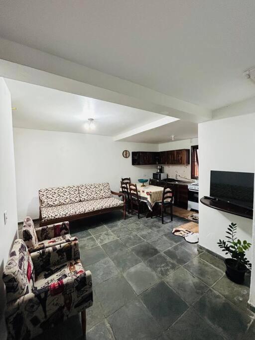 a living room with a couch and a table at Casa pé na areia praia Garopaba in Garopaba