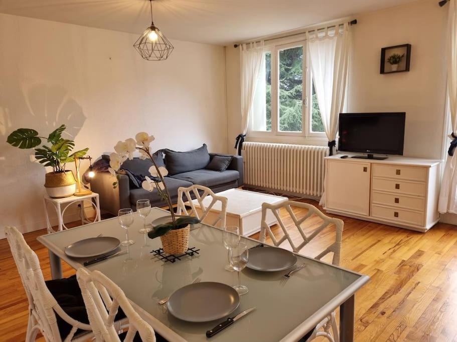 un salon avec une table, des chaises et un canapé dans l'établissement Grand T2 centre ville proche pistes ski et thermes, à Luchon