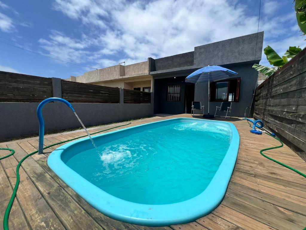a swimming pool with a water fountain on a deck at Tranquilidade e água fresca! in Tramandaí