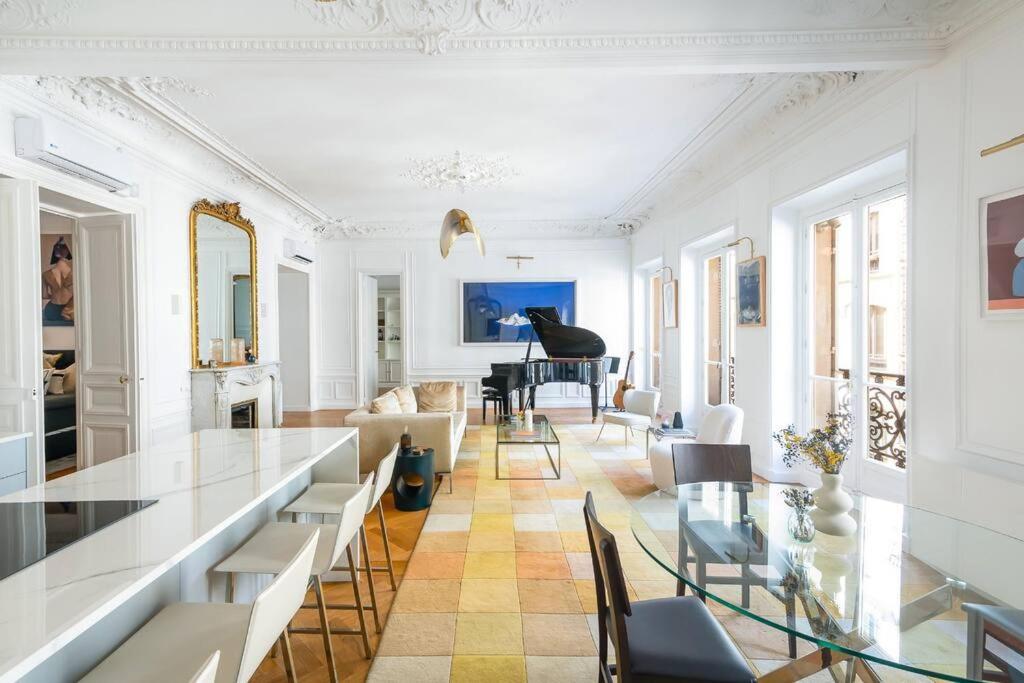 - un salon avec une table en verre et un piano dans l'établissement Luxury High End Condo in the Heart of Paris, à Paris