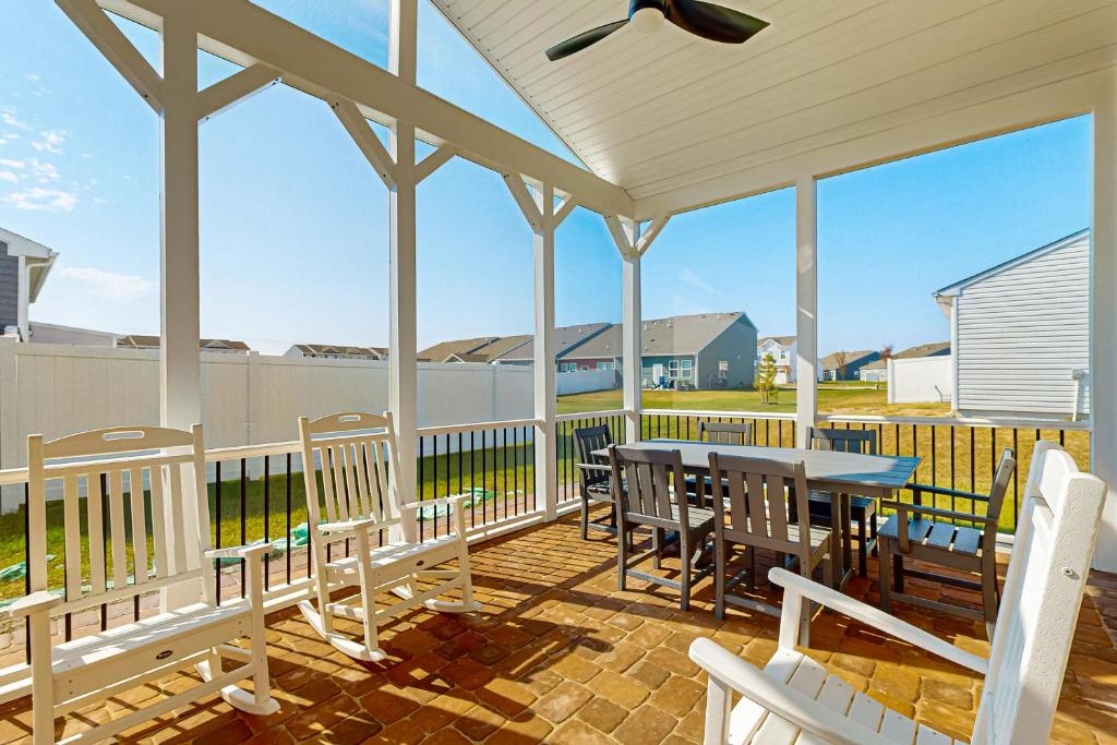 a porch with a table and chairs on it at Millville By The Sea in Millville