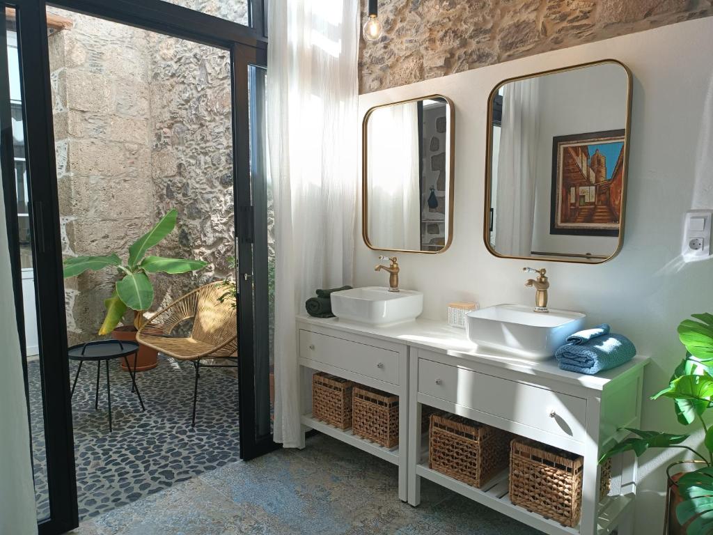 a bathroom with two sinks and two mirrors at Casa Bailarina, romantický kamenný dům s úžasným výhledem na oceán in Agaete