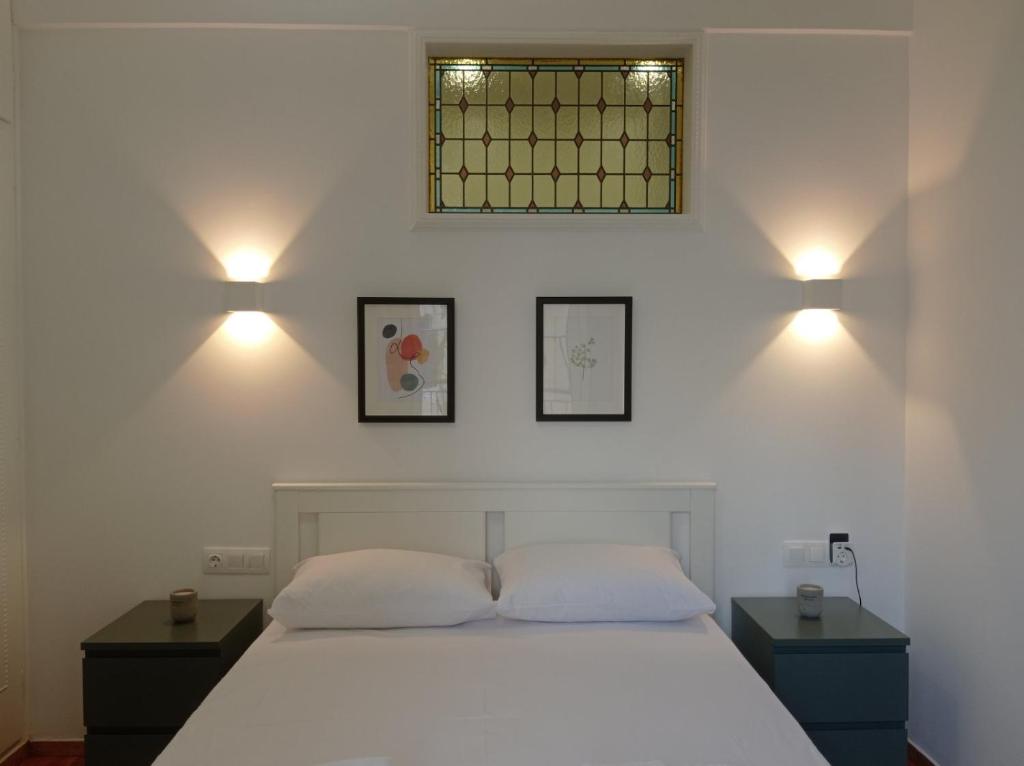1 dormitorio con 1 cama blanca con 2 mesitas de noche y 2 lámparas en Parthenon retreat, en Atenas