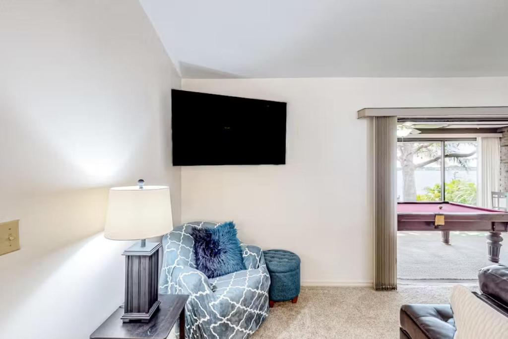 sala de estar con silla y TV de pantalla plana en Charming Lakefront Home Hot Tub, en Eagle Lake