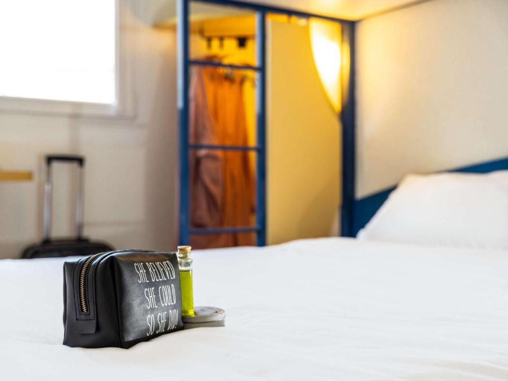 eine schwarze Handtasche auf dem Bett in der Unterkunft Ibis Budget Graz City in Graz