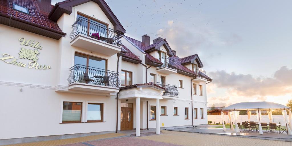 薩比諾沃的住宿－Willa Złota Róża，带阳台和凉亭的白色建筑