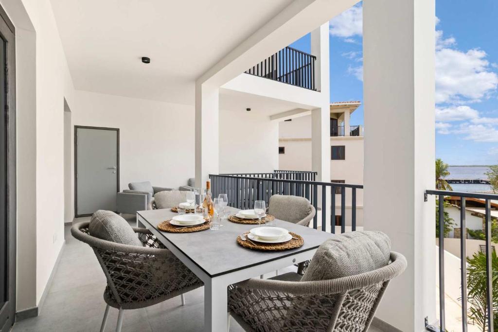 a dining room with a table and chairs on a balcony at Bonaire Beach Apartment 12 with communal pool and diving facilities in Kralendijk