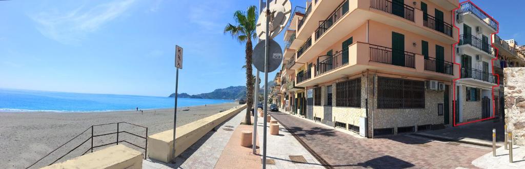 a building on a beach next to the ocean at Appartamento Mare Marconi in Letojanni