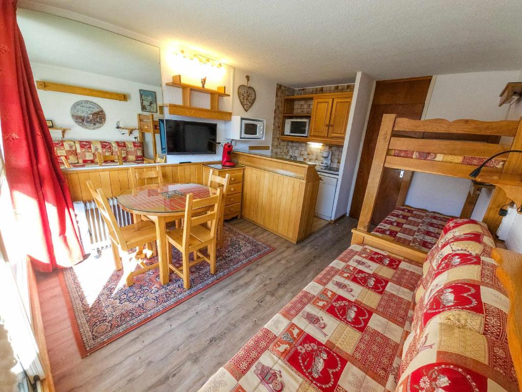 une chambre avec un lit et une cuisine avec une table dans l'établissement Studio équipé au pied des pistes, Les Menuires - FR-1-452-103, aux Menuires