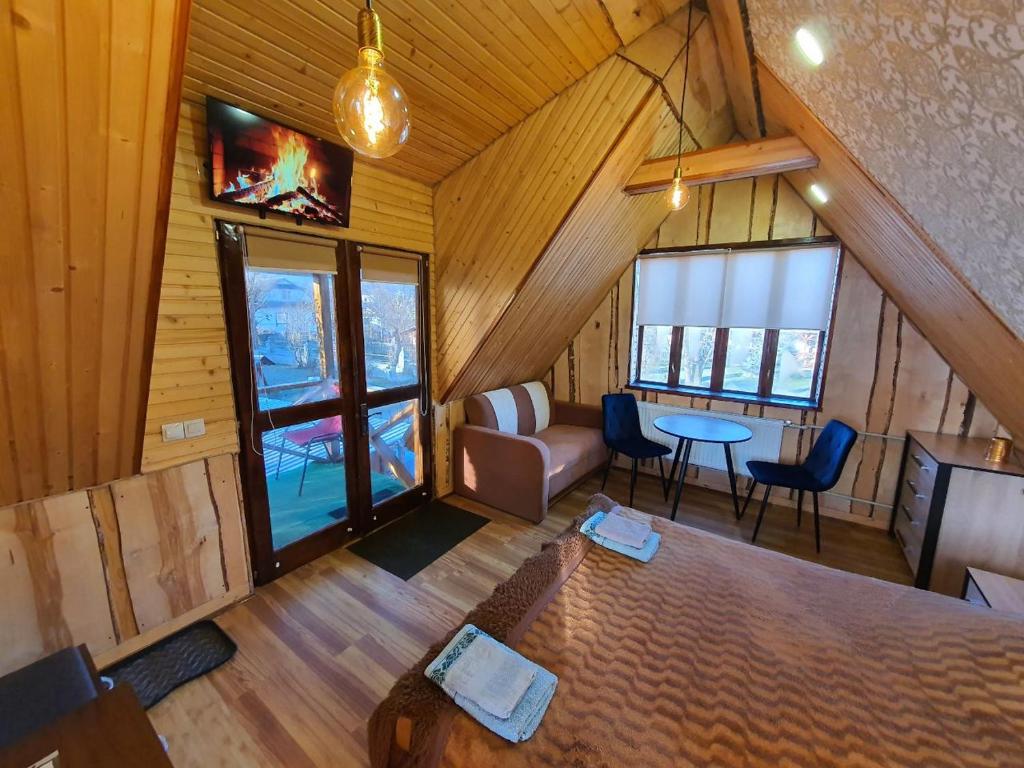 a room with a bed and a couch and a table at Lavanda cottage in Verkhovyna